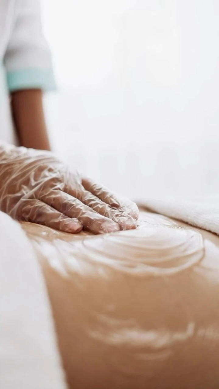 Hands applying a foaming body treatment